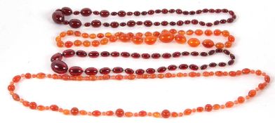 Two 'cherry amber' bead necklaces, another faux amber bead necklace and a carnelian bead
