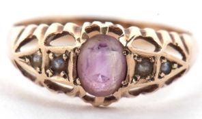 A 9ct amethyst and seed pearl ring, the oval amethyst set with two seed pearls to either side,