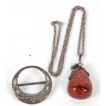 An amber pendant and a brooch, the pear shaped amber cabochon, approx. 4cm long, collet mounted with