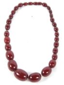 A 'cherry amber' bead necklace, the graduated oval beads between 7 -21mm diameter, approx. 46cm long