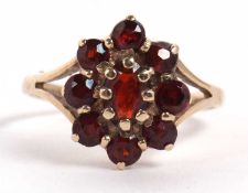 A 9ct garnet cluster ring, set with oval garnets, with split shoulders and plain band, hallmarked