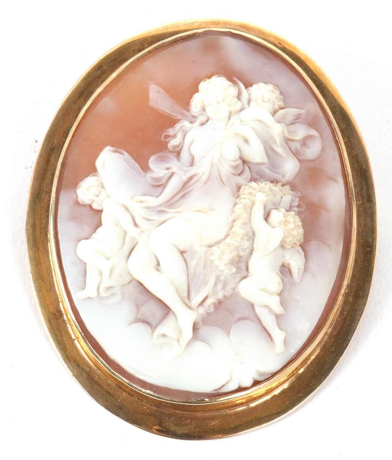 An oval shell cameo of a classical maiden and three cherubs, collet mounted with pin to reverse,