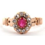 A ruby and diamond ring, the oval ruby surrounded by rose cut diamonds, all claw mounted with