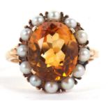 A 9ct citrine and cultured pearl ring, the oval citrine in a four claw mount and surrounded by small