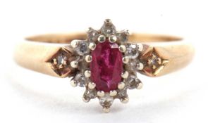 A 9ct ruby and diamond ring, the central oval ruby surrounded by small round diamonds, with
