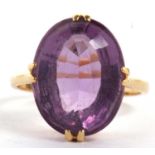 An 18ct amethyst ring, the oval amethyst in four double claw mount, with plain band stamped 18ct,