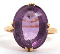 An 18ct amethyst ring, the oval amethyst in four double claw mount, with plain band stamped 18ct,