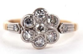 A diamond flowerhead cluster ring, comprised of single cut diamonds, with a single cut diamond to
