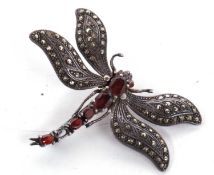 A silver garnet and marcasite dragonfly brooch, the body set with oval faceted garnets with