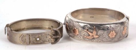 A silver hinged bangle, 22mm wide, with engraved decoration and bi-colour swallows and ivy