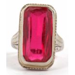 An 18kt synthetic ruby ring, the rectangular radiant synthetic ruby, collet mounted with