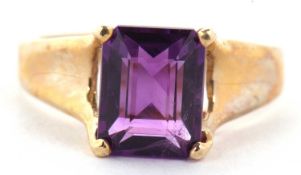 A 9ct amethyst ring, the emerald cut amethyst in a four claw mount, with split tapered shoulders and