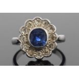 A sapphire and diamond cluster ring, the cushion shaped faceted sapphire is 7x7x4mm approx, bezel