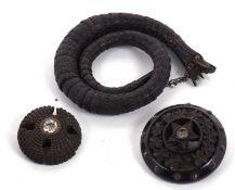 A bog oak snake bracelet and two brooches, the snake head with amber glass eyes and naturalistically
