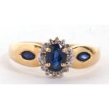An 18ct sapphire and diamond ring, the central oval sapphire surrounded by small round diamonds,