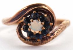 A 9ct sapphire and opal ring, the central round opal cabochon, surrounded by small round