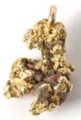 A gold nugget pendant, the natural gold nugget, tests as approx. 18ct gold, with come crystal