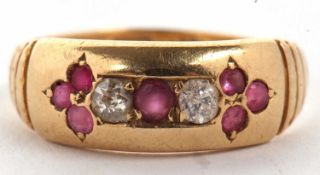 An 18ct ruby and diamond ring, the central round ruby set to either side with a round diamond and