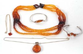 A quantity of amber jewellery to include a four strand faceted amber bead necklace, 40g, two