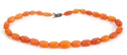 An amber bead necklace, the oval amber beads, between approx. 8.8 - 14.4mm, with a silver