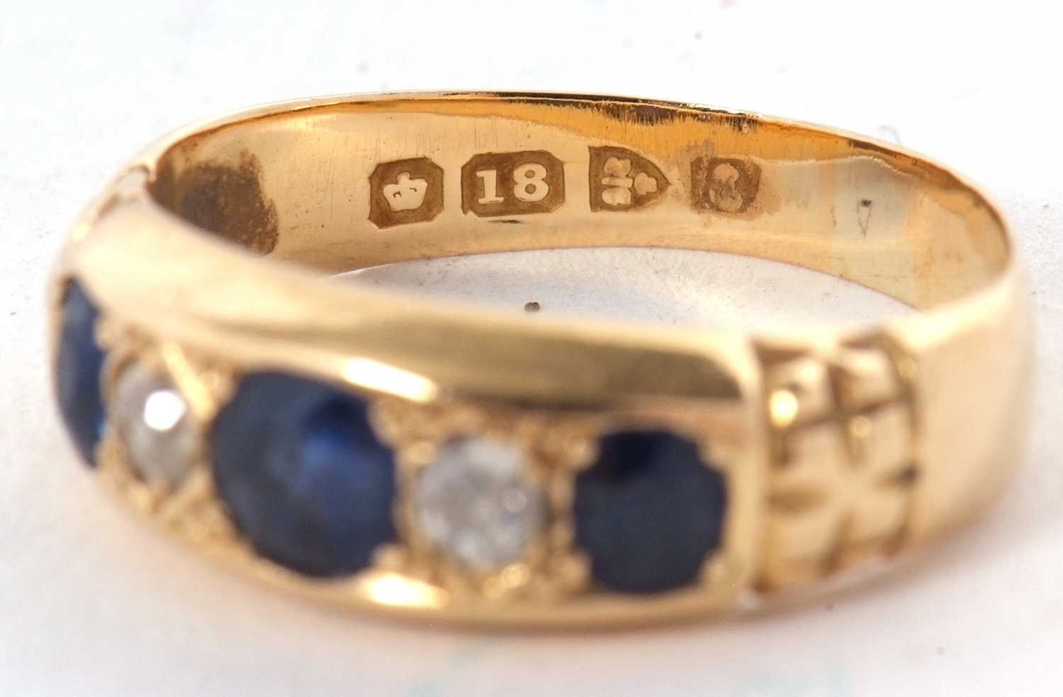 An Edwardian 18ct sapphire and diamond ring, the three graduated round sapphires interspaced with - Image 6 of 7