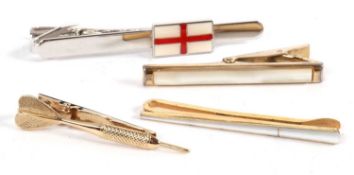 Four tie clips, to include a gilt metal clip with a dart to the front, one with the flag of St