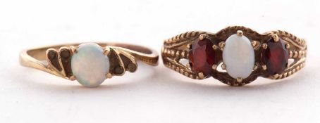 A 9ct opal and garnet ring, the oval opal cabochon with an oval garnet to either side, with split