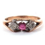 A 9ct ruby and diamond ring, the central claw mounted round ruby set to either side with a small