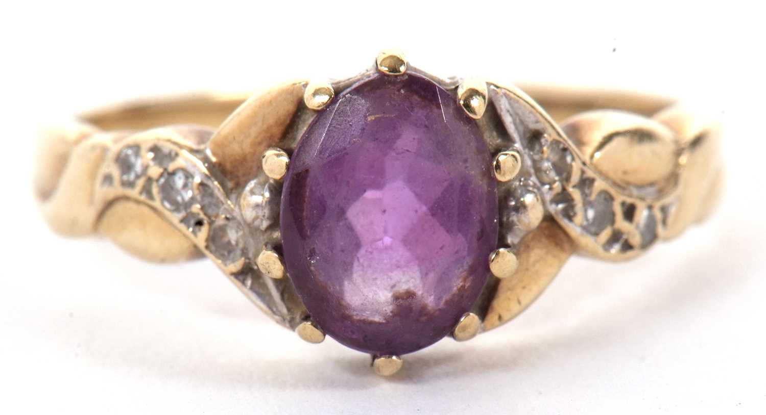 A 9ct amethyst and diamond ring, the oval amethyst with crossover style shoulders set with small