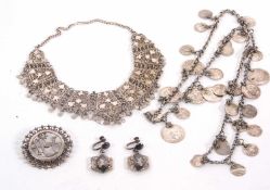 A quantity of white metal jewellery to include a Middle Eastern coin style necklace, a round