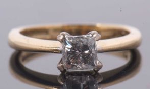 An 18ct princess cut diamond ring, wieght approx. 0.75cts, in a four claw mount to a plain band
