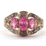 A 9ct pink gemstone and diamond ring, the three oval pink gemstones, claw mounted with shaped