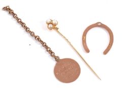 A stick pin and horsehsoe charm, the stick set with a split pearl and rose cut diamond playing