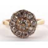 An 18ct diamond cluster ring, the central round raised diamond surrounded by mixed cut diamonds, all