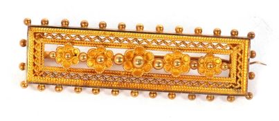 An Etruscan revival bar brooch, the rectangular panel set with small flowers with rope twist and