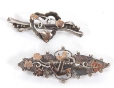 Two early 20th century silver brooches, one marquise shape with a bi-colour anchor and foliate