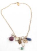 A silver gilt charm necklace by Monica Vinander, the vermeil chain with a variety of charms to