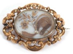 A 19th century memorial brooch, the oval glazed panel set with hairwork and seed pearls, collet