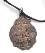 A silver pendant by Malcolm Appleby, depicting a galleon at sea within a surround of fish tails