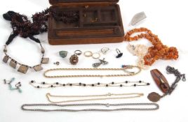 A mixed group of costume jewellery to include an amber chip necklace, faux pearls, eastern white