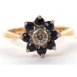 An 18ct sapphire and diamond ring, the central small round illusion set diamond surrounded by