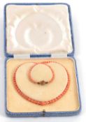 A coral and seed pearl choker, the graduated round coral beads separated by seed pearls, with