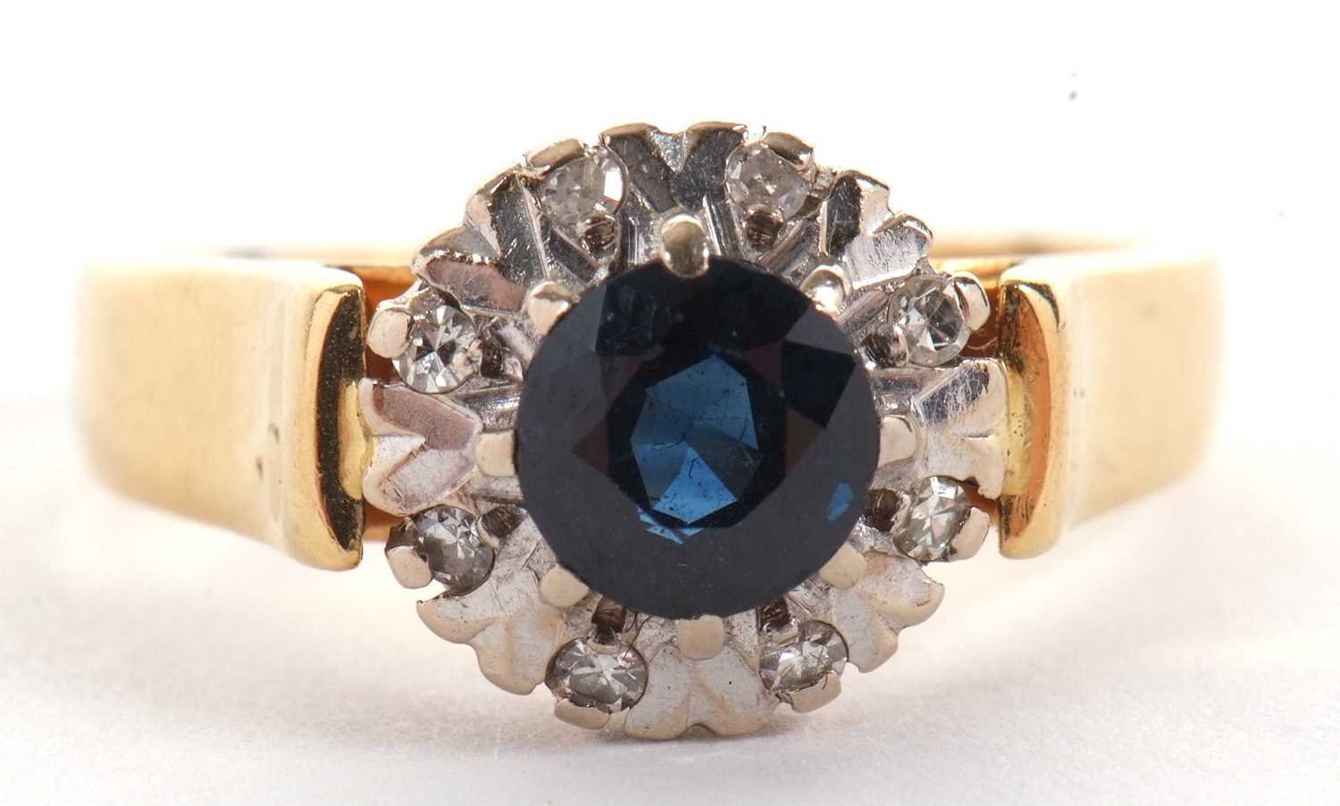 An 18ct sapphire and diamond ring, the central round sapphire surrounded by illusion set diamonds,