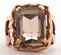 A citrine dress ring, the emerald cut citrine, in a four claw mount with split shoulders and plain