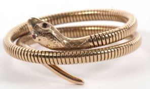 A 9ct coiled snake bracelet, with naturalistic head with engraved decoration and red stone eyes (one