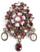 A 19th century Iberian style garnet, pearl and enamel brooch, the central striped white enamel and