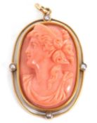 A late 19th century coral cameo, the carved oval coral cameo of a lady, collet mounted with an outer