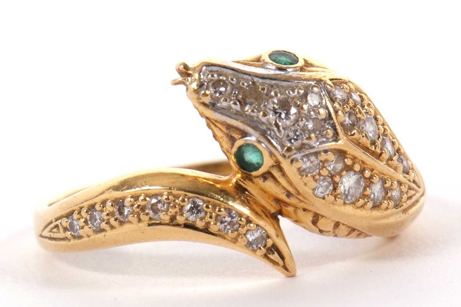 An 18ct snake head ring, the naturalistically modelled head pave set with diamonds and green