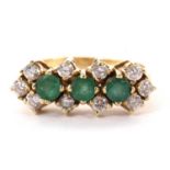 A 14ct emerald and white stone ring, the three round emeralds interspaced with a single round