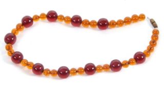 A faux amber necklace, comprised of round golden and cherry faux amber beads, with gilt metal barrel
